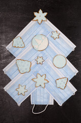 christmas tree made of medical masks decorated with christmas cookies, coronavirus, concept photo, gingerbread cookies decorated with blue icing