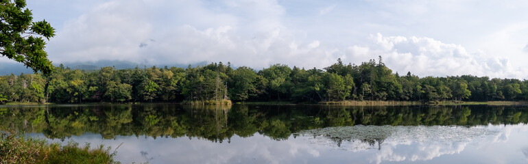 Fototapeta na wymiar Panoramic view of forest reflecting in one of Shiretoko Five Lakes