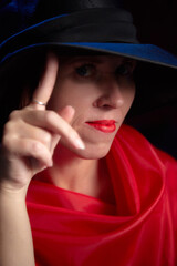 Portrait of ugle middle-aged woman with hat and red dress. Ugly model looking as lady posing in studio.