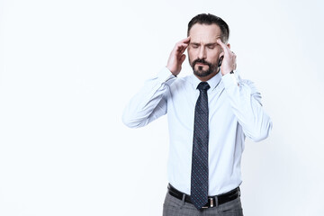 A man in a shirt holds his hands on his head.