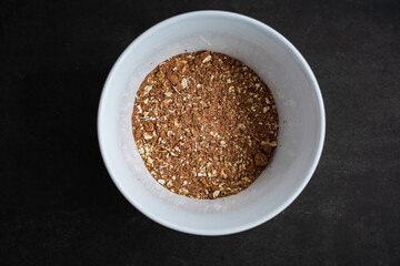 breakfast of healthy banana flakes with chocolate, oat, granola in a white bowl.