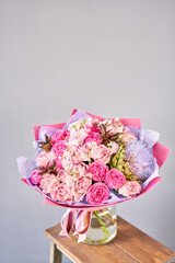 purple and pink bouquet with the flower of the artichoke. Beautiful flowers on wooden table. Floristry concept. Spring colors. the work of the florist at a flower shop.