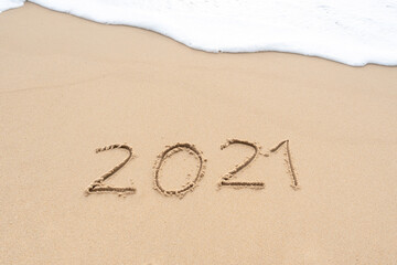 Fototapeta na wymiar Happy New Year 2021 text on the sandy beach. Welcoming 2021 with new resolutions, dreams concept.