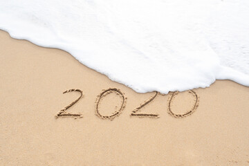 Handwritten 2020 on beautiful sand beach. Goodbye 2020 concept