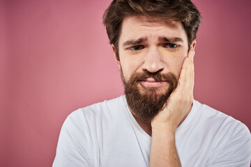 bearded man in white t-shirt emotions displeased facial expression studio pink background