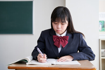教室で真剣に授業を受ける日本人女子中学生
