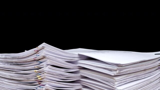 Stop motion animation Stacks overload document paper files rotation on office desk isolated on black background, Business concept, Close up.