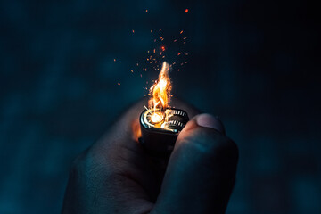 The hand is lighting the lighter