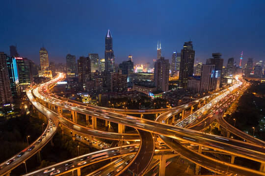 Elevated road junction and skyline of Shanghai, China at dusk.