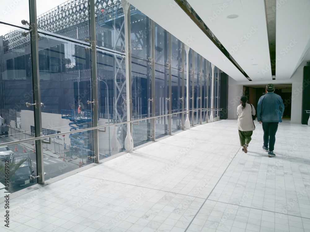 Wall mural auckland, new zealand - oct 07, 2019: couple walking inside sky bridge in westfield newmarket shoppi