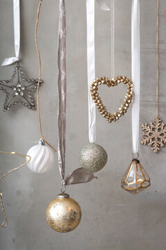 Christmas decorations, close up of silver, white and golden Christmas baubles on ribbons