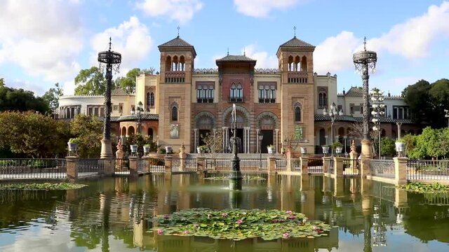 fountain in the park with a beautiful building like a palace - Seville in Spain