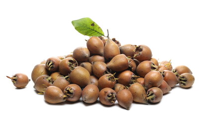 Fresh medlar fruits pile with green autumn leaf isolated on white background
