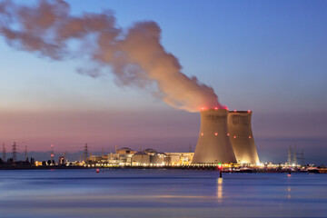Obraz na płótnie Canvas Riverbank with nuclear power plant Doel during a colorful sunset, Port of Antwerp, Belgium