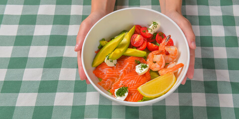Fresh salad with seafoods, tomato and herbs. Red salmon, small shrimps, avocado, cherry tomatoes.