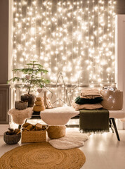 Classic apartments with decorated christmas tree and presents. Christmas evening in the light of candles and garlands. Living with fireplace and stucco.