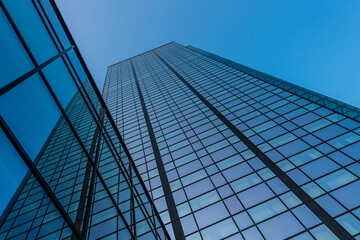 Looking up a tall glass and steel high-rise building..