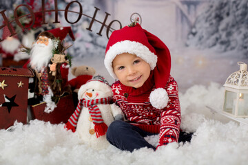 Cute boy, toddler child, playing in the snow outdoors