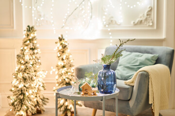 Classic apartments with decorated christmas tree and presents. Christmas evening in the light of candles and garlands. Living with fireplace and stucco.