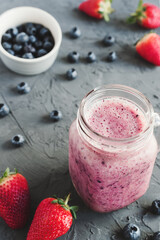 Homemade blueberry and strawberry smoothie drink on concrete background. Detox cocktail