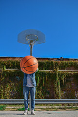 Young man playing basketball jumping towards the basket.