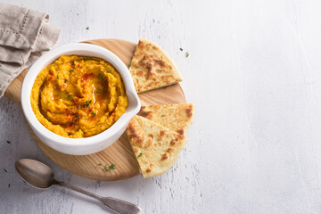 Delicious healthy homemade bean hummus with baked pumpkin, tahina and spices with flat bread on a...