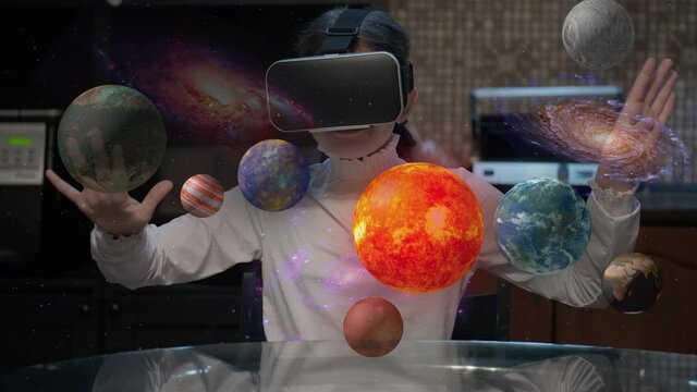 Child in virtual reality glasses looks at a hologram of the solar system and planets. Distance learning, fun and augmented reality games