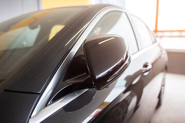 Fototapeta na wymiar Modern folding mirrors with turn signal in a black new car, close-up