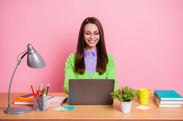 Photo of smart girl expert sit table work laptop wear green shirt isolated over pastel color background