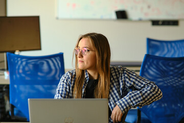 The programmer girl works at the computer	Girls in science. In an empty office during a pandemic.