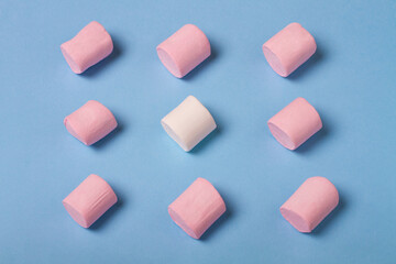Colorful marshmallow on blue background. Pink and white marshmallow top view.