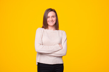 Fototapeta premium A photo of a standing woman with her arms crossed is smiling at the camera .