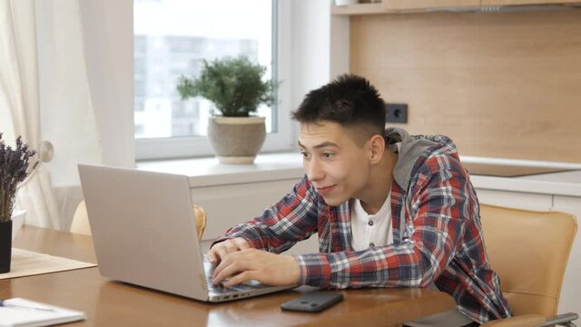 Young overjoyed excited joyful man receiving reading great news, smiling happy guy surfing web internet using laptop computer, celebrating success victory