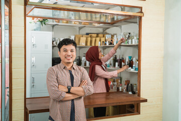 portrait young man and muslim woman selling packaged products