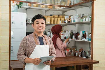 Fototapeta premium portrait young man and muslim woman selling packaged products