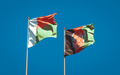Beautiful national state flags of Madagascar and Afghanistan together at the sky background. 3D artwork concept.