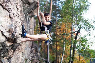 cute teen kid climbing on rock with insurance, lifestyle sport people concept