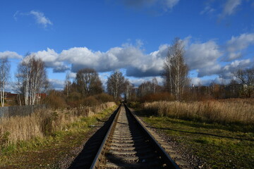 Fototapeta na wymiar A narrow-gauge railway close-up extending into the distance. Bare trees along the railway