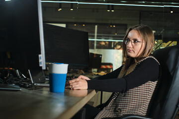 The programmer girl works at the computer	Girls in science. In an empty office during a pandemic.