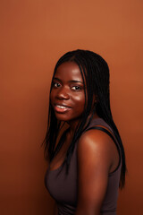 pretty young african american woman posing cheerful gesturing on brown background, lifestyle people concept