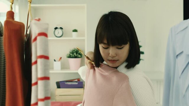 Young asian short bob hairstyle woman in bathrope finding cloth on a rack.