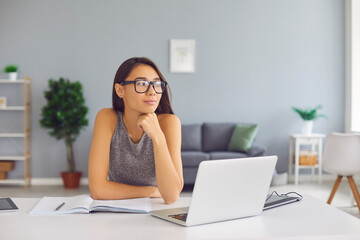 Creative student, writer or business course author sitting at desk with laptop and thinking