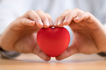 Red heart in hands. Health insurance or love concept.
