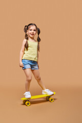 Fototapeta na wymiar Young girl learning to ride on skateboard