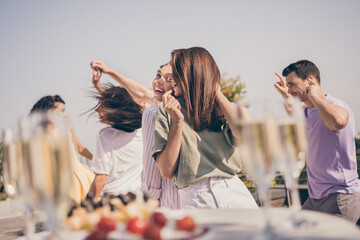 Photo of cheerful pretty guys have fun dancing meals drinks on table party on roof terrace outside