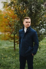Portrait of a young handsome man, model of fashion, with modern hairstyle in urban background, wearing casual clothes.