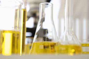 Flasks and test tubes contain yellow liquid. Experiments and research in field of pharmaceuticals concept
