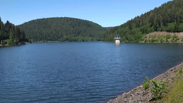 Langsamer Schwenk &uuml;ber die Talsperre Kleine Kinzig mit Wellen auf der Wasseroberfl&auml;che - Blick vom Staudamm bei Alpirsbach, Schwarzwald, Deutschland