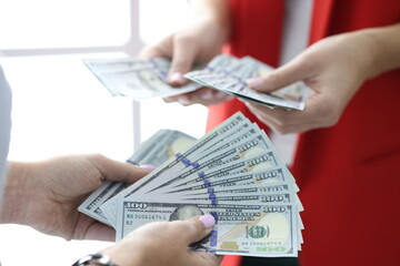 One hundred USA dollar bills are being counted in their hands. Development of small and medium-sized enterprises and business concept