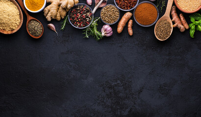 Obraz na płótnie Canvas Collection of spices on dark background. Cumin, mustard powder, garlic, basil, peppercorns, turmeric, root, ginger, rosemary, paprika, red pepper, .thymus, coriander.